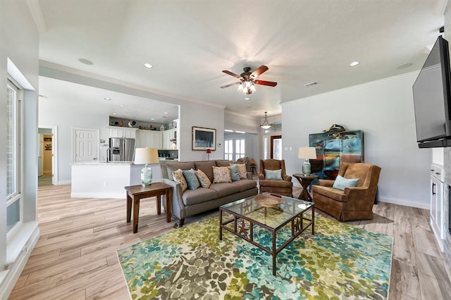 living room featuring ornamental molding, light hardwood / wood-style floors, and ceiling fan