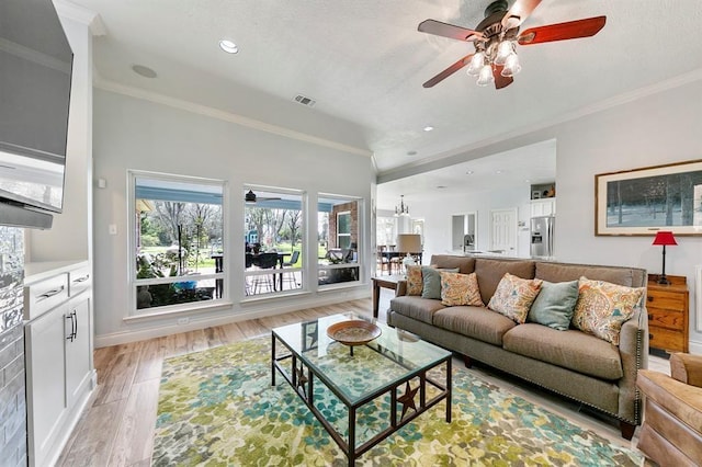 living room featuring ornamental molding, ceiling fan, and light hardwood / wood-style flooring