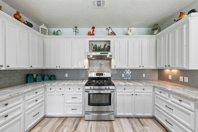 kitchen featuring white cabinetry, light stone counters, light hardwood / wood-style flooring, and stainless steel gas stove