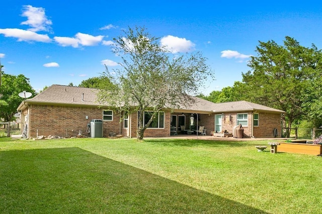 back of property with central AC unit, a patio area, and a lawn