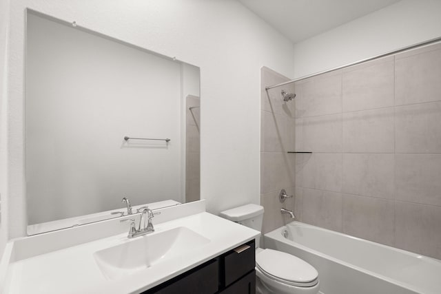 full bathroom featuring tiled shower / bath, vanity, and toilet