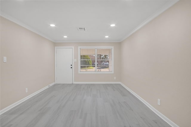 empty room featuring ornamental molding and light hardwood / wood-style floors