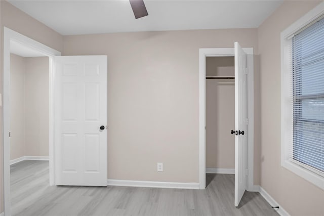 unfurnished bedroom featuring a closet, ceiling fan, and light wood-type flooring