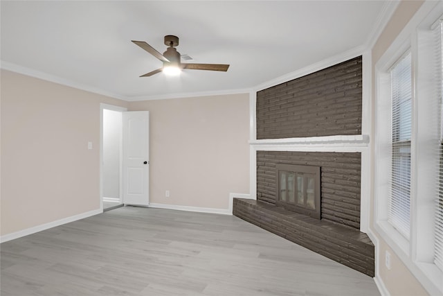 unfurnished living room with crown molding, ceiling fan, a fireplace, and light wood-type flooring