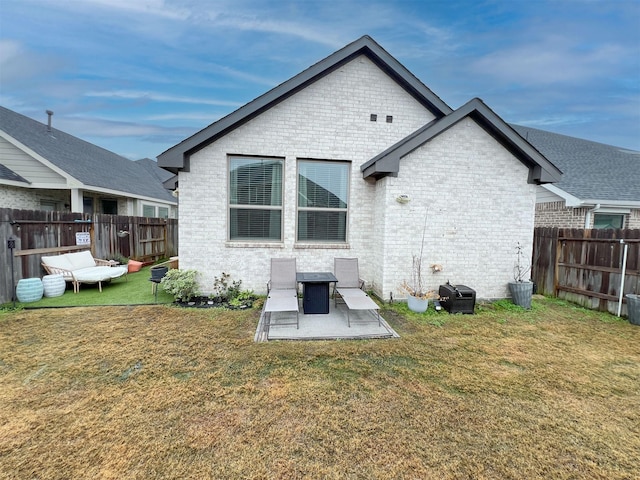 back of house with a patio area and a lawn