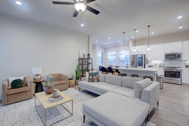 living room featuring ceiling fan and light hardwood / wood-style floors