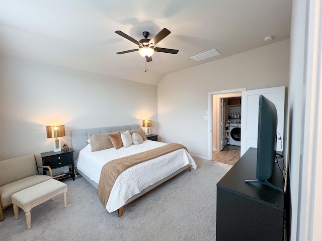 bedroom featuring ceiling fan, lofted ceiling, and washer / clothes dryer