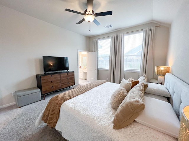 carpeted bedroom featuring vaulted ceiling, connected bathroom, and ceiling fan