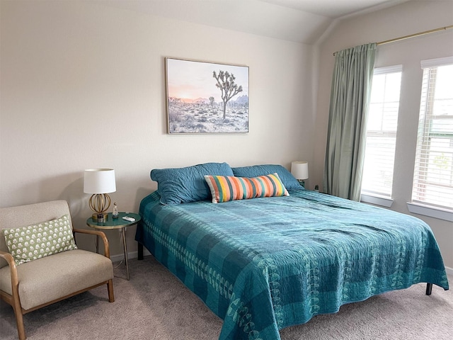 bedroom with multiple windows, vaulted ceiling, and carpet floors