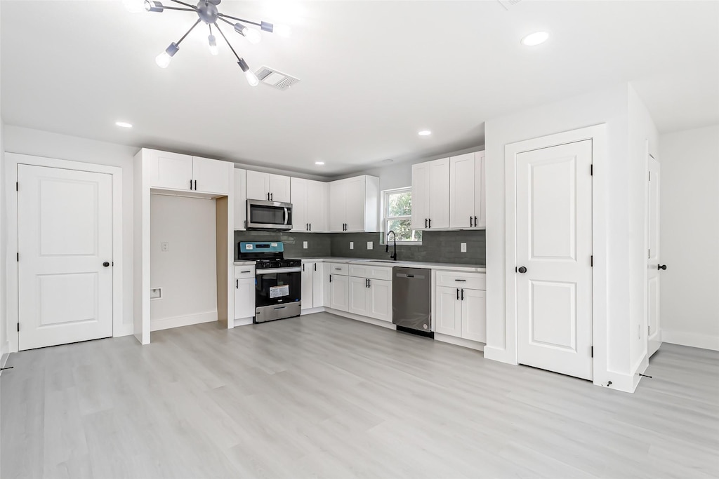 kitchen featuring stainless steel appliances, sink, and white cabinets