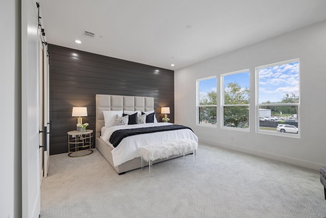 bedroom with light carpet and wood walls