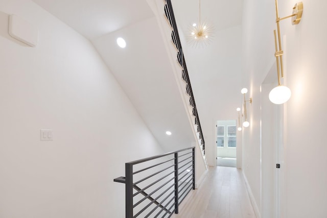 hall with an inviting chandelier and light hardwood / wood-style floors