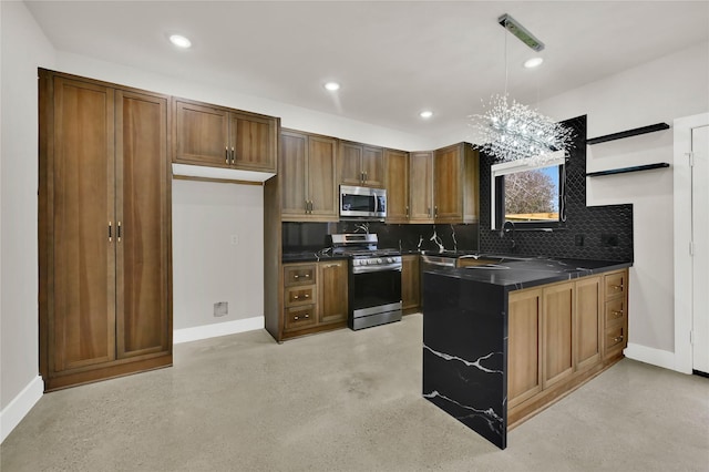 kitchen featuring pendant lighting, sink, backsplash, kitchen peninsula, and stainless steel appliances