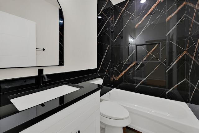 full bathroom featuring vanity, tiled shower / bath combo, and toilet