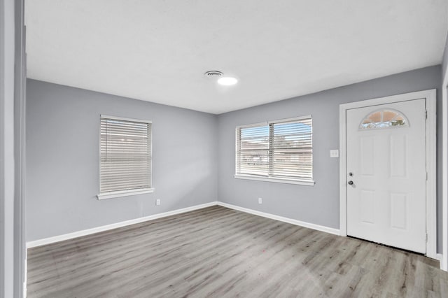 foyer with visible vents, baseboards, and wood finished floors