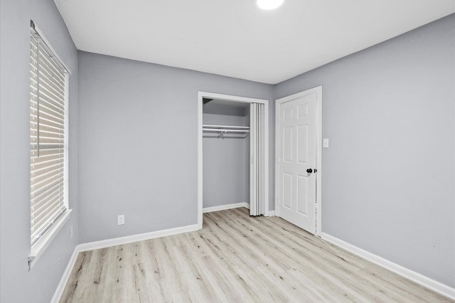 unfurnished bedroom featuring a closet, baseboards, and wood finished floors