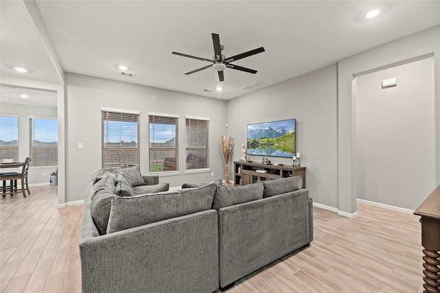 living room with light hardwood / wood-style flooring and ceiling fan