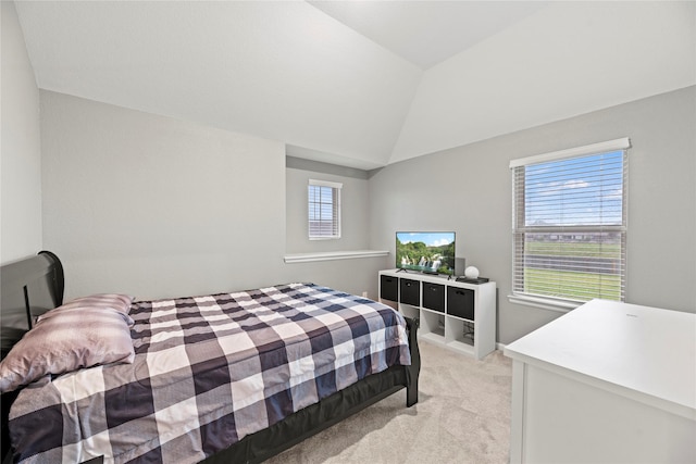 bedroom featuring light colored carpet and lofted ceiling