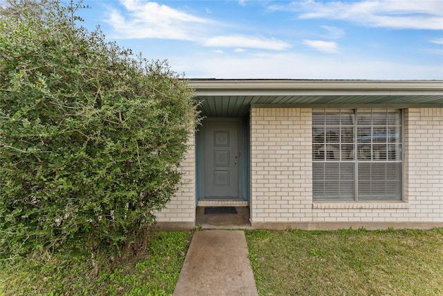 doorway to property featuring a lawn