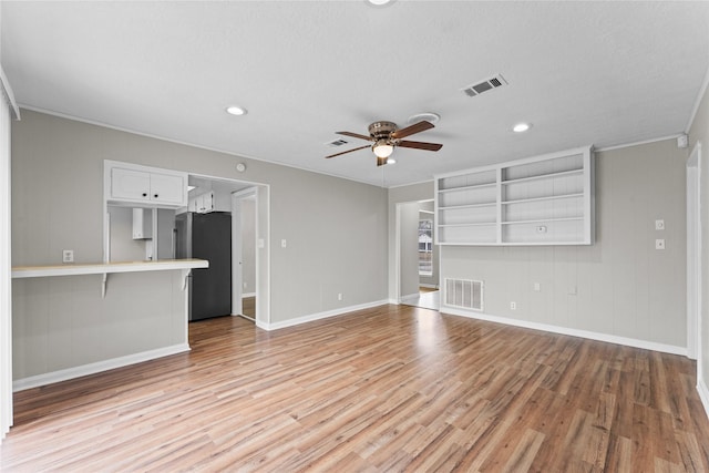 unfurnished living room featuring crown molding, ceiling fan, and light wood-type flooring