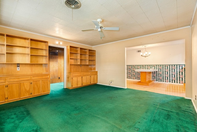 unfurnished living room featuring ceiling fan with notable chandelier, ornamental molding, and dark carpet