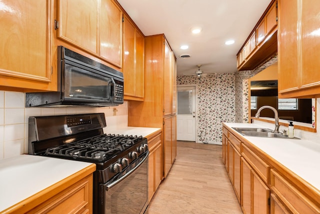 kitchen with sink, decorative backsplash, ceiling fan, black appliances, and light wood-type flooring