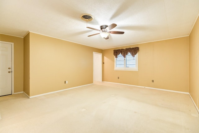 empty room with crown molding, carpet floors, and ceiling fan