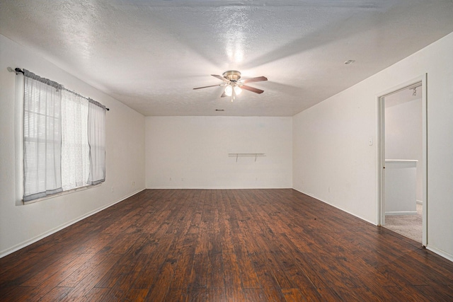 empty room with dark wood-type flooring, ceiling fan, and a textured ceiling