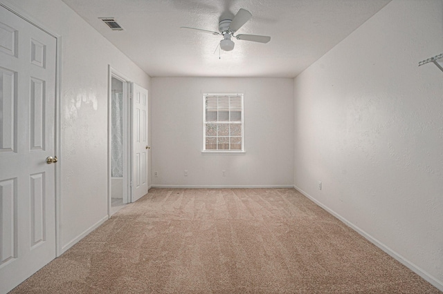 carpeted spare room with ceiling fan and a textured ceiling