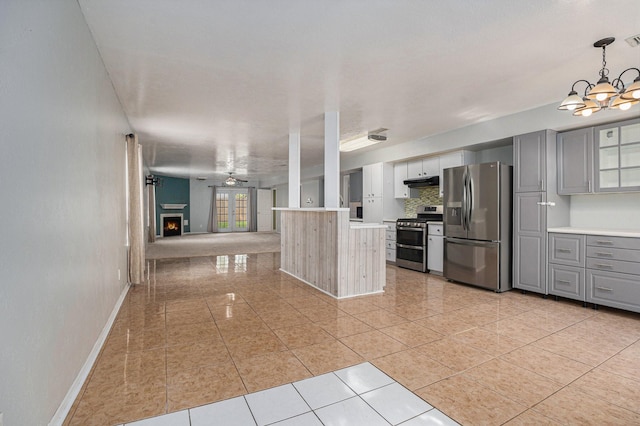 kitchen with light tile patterned floors, gray cabinets, ceiling fan with notable chandelier, appliances with stainless steel finishes, and decorative light fixtures