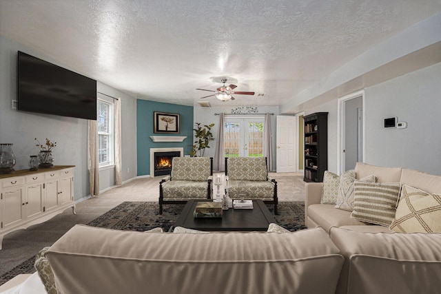 carpeted living room with ceiling fan and a textured ceiling