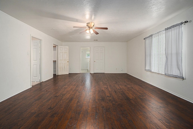 unfurnished room with a textured ceiling, dark wood-type flooring, and ceiling fan