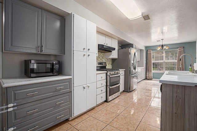 kitchen featuring white cabinetry, sink, gray cabinetry, hanging light fixtures, and stainless steel appliances