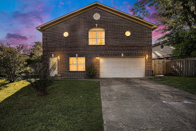 view of property featuring a garage and a lawn