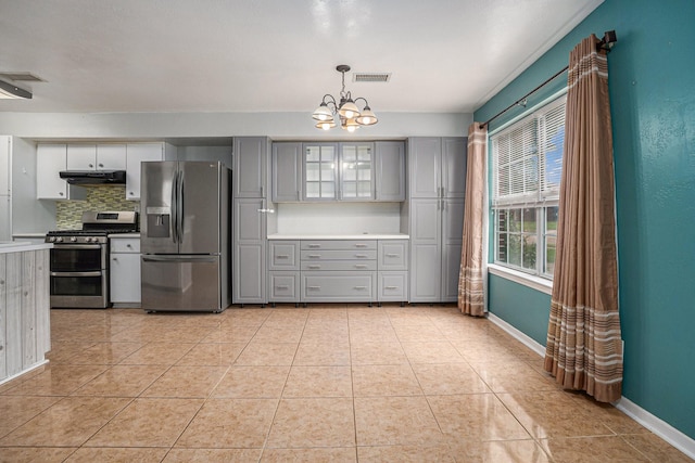 kitchen with gray cabinetry, tasteful backsplash, hanging light fixtures, light tile patterned floors, and stainless steel appliances