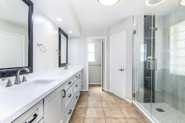 bathroom with walk in shower, vanity, and tile patterned flooring