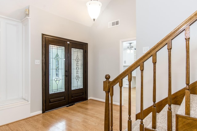 entrance foyer featuring high vaulted ceiling, light hardwood / wood-style floors, and french doors