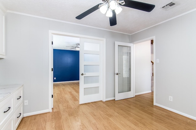 unfurnished bedroom with light wood-type flooring, ornamental molding, ceiling fan, a textured ceiling, and a closet