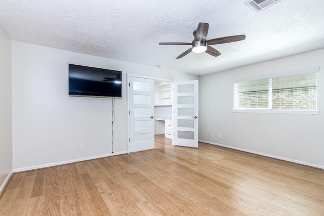 unfurnished bedroom with ceiling fan, light hardwood / wood-style flooring, and a textured ceiling