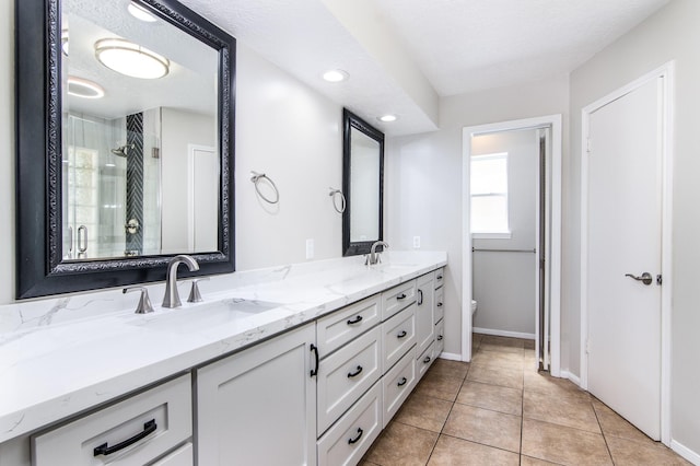 bathroom with vanity, tile patterned flooring, a shower with shower door, and toilet