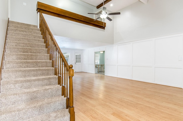 stairway with hardwood / wood-style floors, beamed ceiling, and ceiling fan