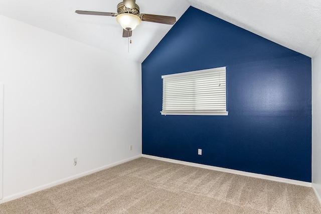 spare room featuring lofted ceiling, carpet floors, and ceiling fan