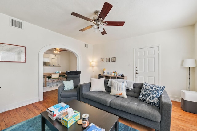 living room featuring ceiling fan and hardwood / wood-style floors