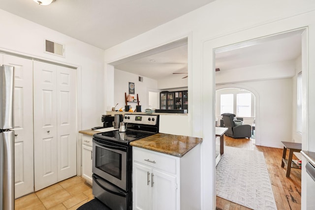 kitchen with appliances with stainless steel finishes, light wood-type flooring, white cabinets, and ceiling fan