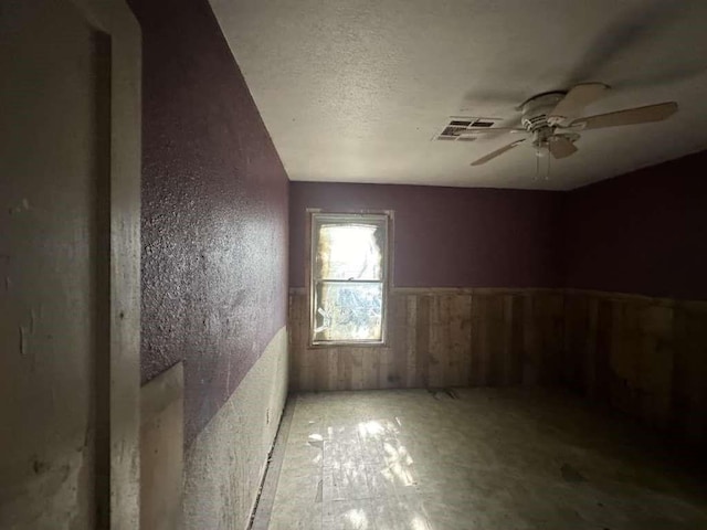 unfurnished room with a textured ceiling and ceiling fan