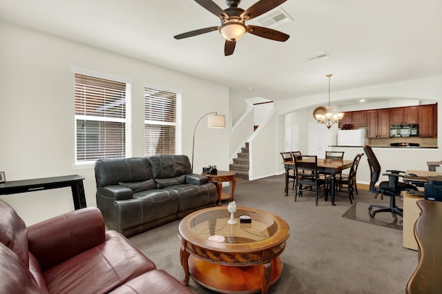 living room featuring ceiling fan with notable chandelier and light carpet