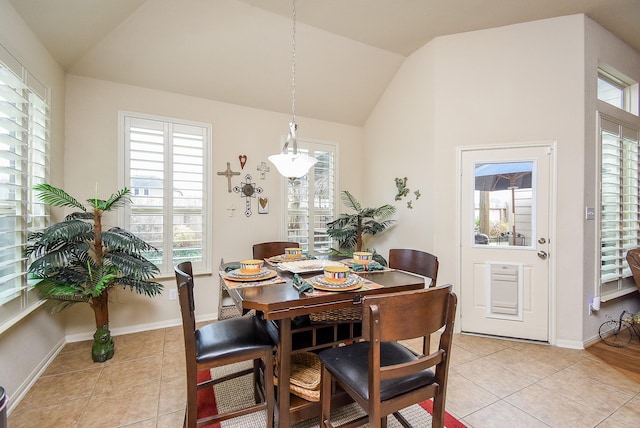 dining room with light tile patterned flooring and vaulted ceiling