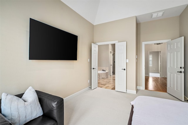 carpeted bedroom with lofted ceiling and ensuite bath