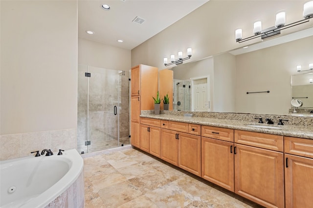 bathroom featuring vanity and independent shower and bath