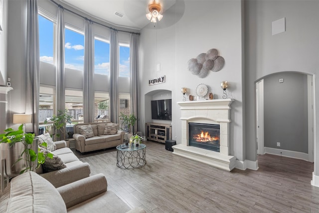 living room featuring ceiling fan, hardwood / wood-style floors, and a high ceiling